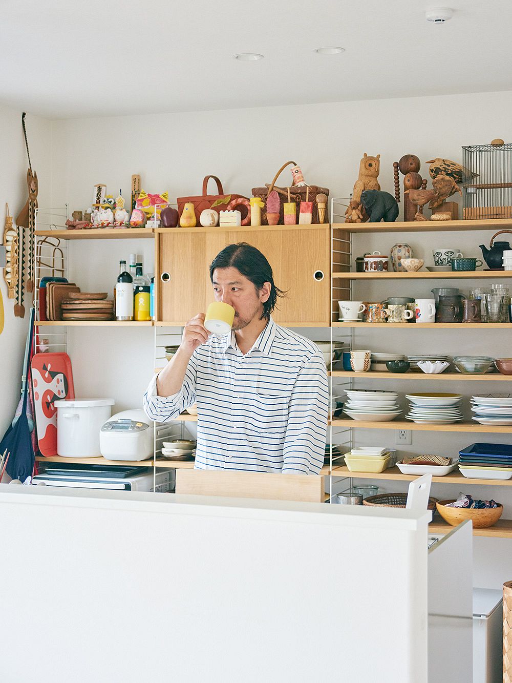 A man drinking coffee at his kitchen.